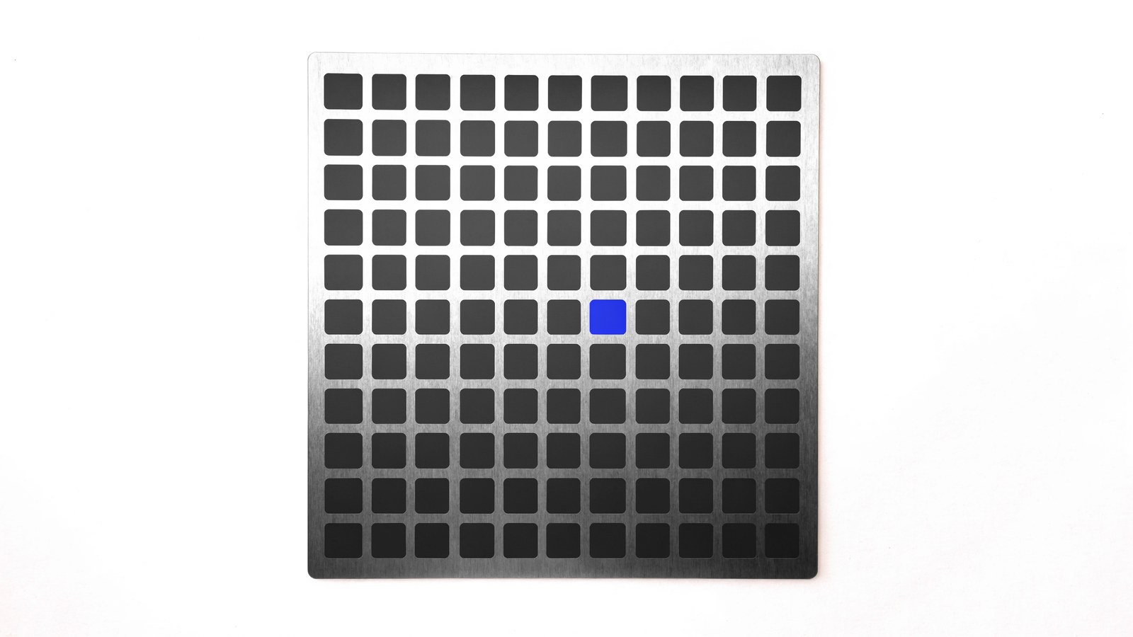 A brushed metal plate of square elements, one picked out in blue