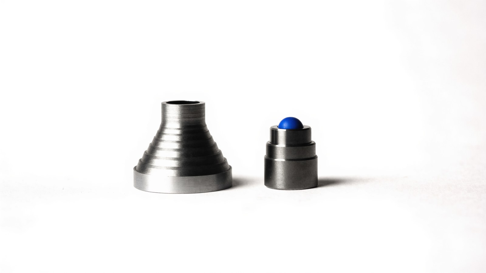 A stepped machined horn beside a smaller mount capped in blue